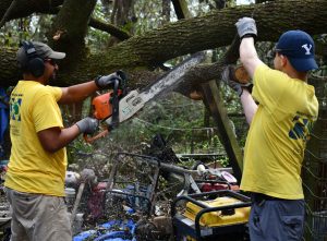 Lane Wright, left, and Josh Matson of Tallahassee team up in cutting a downed tree.