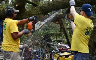 Lane Wright, left, and Josh Matson of Tallahassee team up in cutting a downed tree.