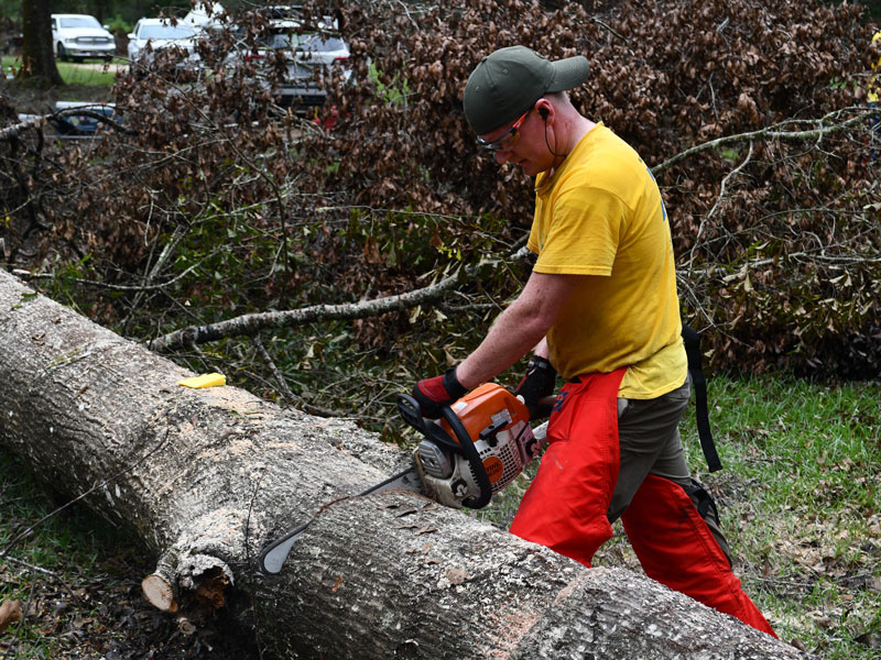 Spencer Youngberg from the Tallahassee Florida Stake works the chainsaw.
