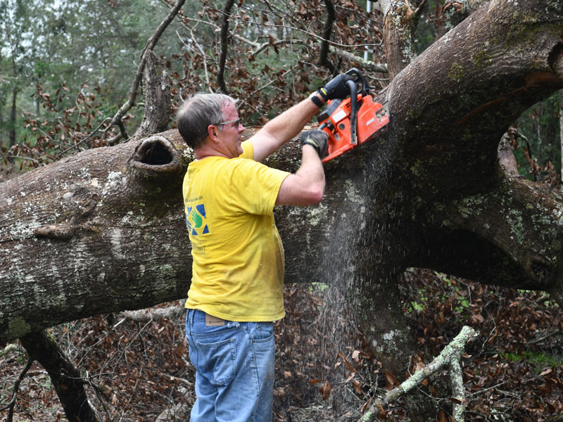 Rodney Schank of the Tallahassee Florida Stake cutting branches.